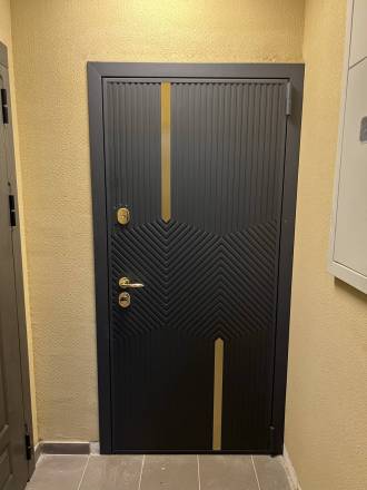 Дверь в квартиру с декоративными элементами из латуни и золотой фурнитурой.