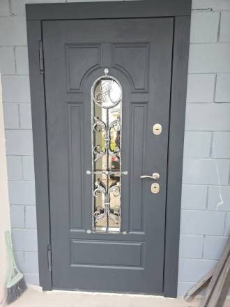 Уличная входная термодверь со стеклопакетом и кованой решёткой с монограммой в виде буквы «А»